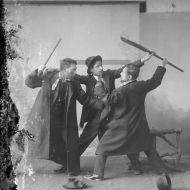Homens em estúdio fotográfico encenando luta
